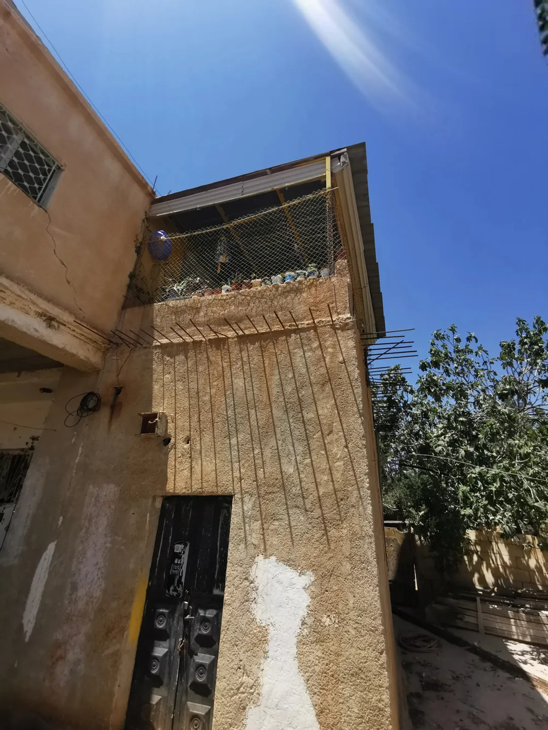 أرض زراعية غنية بالزيتون واللوزيات مع منزل ريفي من طابقين