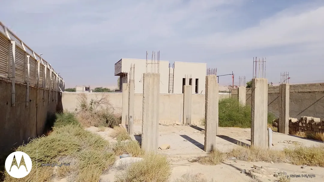 أرض مميزة تضم بناء شاليه عظم مع سور وبوابة