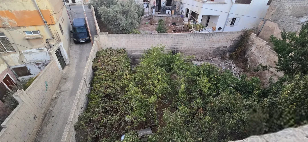 ارض مع بنائين واحد قديم واحد جديد قديم مع قطعه ارص مساحتها 180 متر مسوره ومشجره ومداخل خاصه لحل شقه